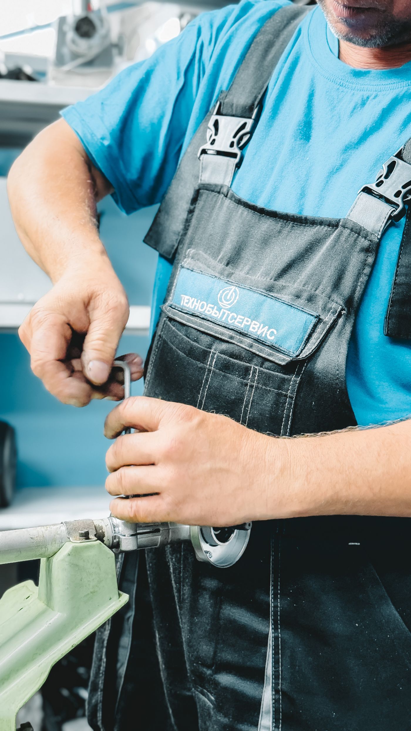 Plumber tightening a pipe connection with a wrench; illustrative stock photo